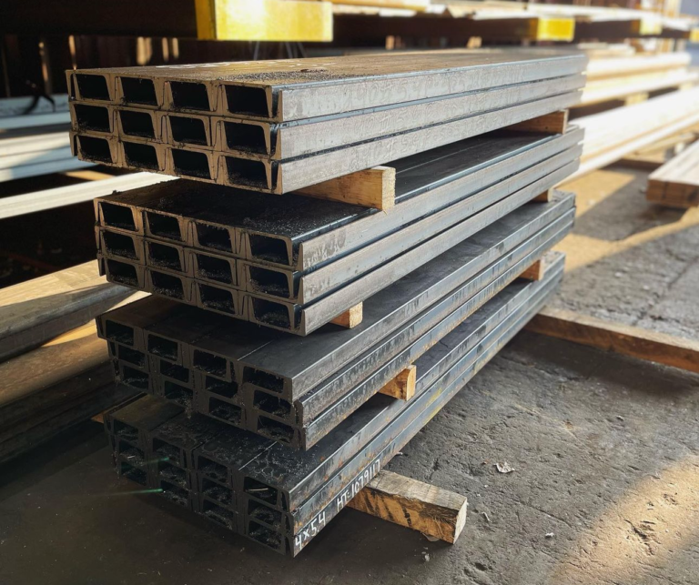 Rows of steel C-channels stacked in your workshop or under fabrication.