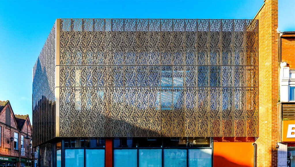 A sleek modern building with brushed metal or perforated panels.