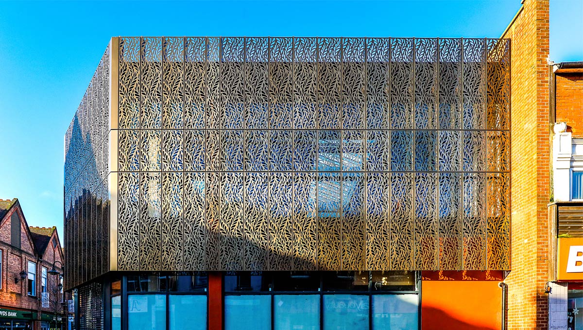 A sleek modern building with brushed metal or perforated panels.